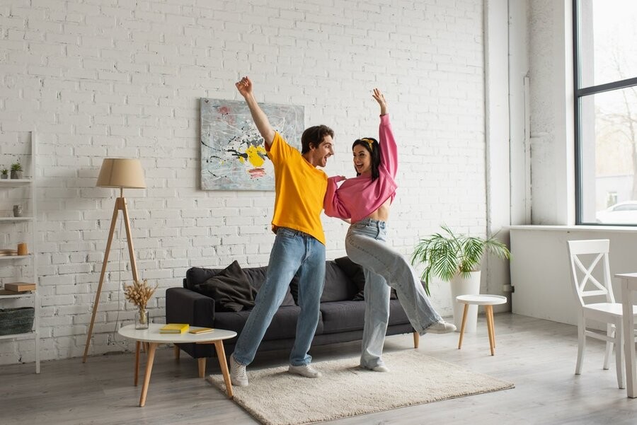 Two people dancing to music via a multi-room audio system.
